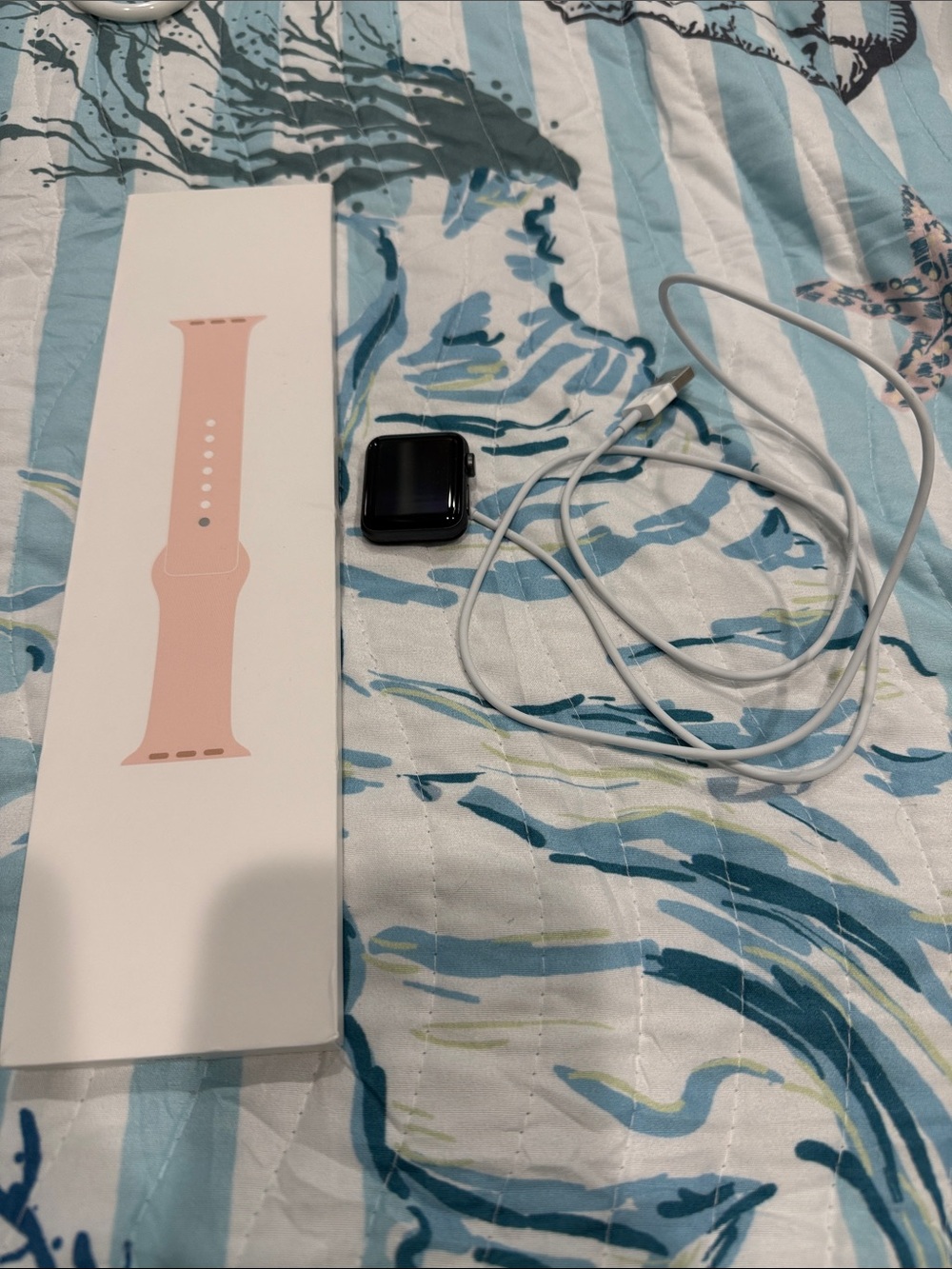 Apple Watch with Pink Sport Band and White Charging Cable